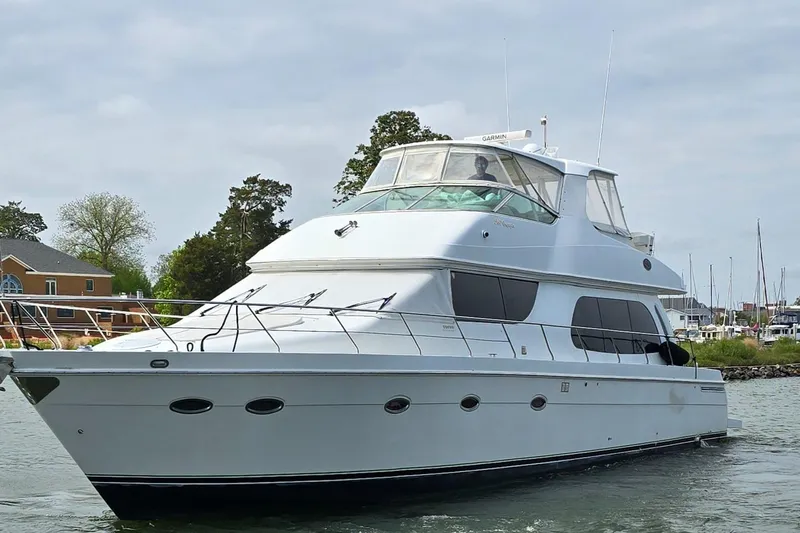 Slide: The Image of 2004 Carver 56 Voyager SE yacht cruising on a calm waterway. - 2