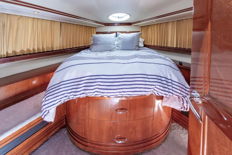 Slide: The Image of Luxurious bedroom in 2004 Carver 56 Voyager SE yacht with wood cabinetry and striped bedding. - 26