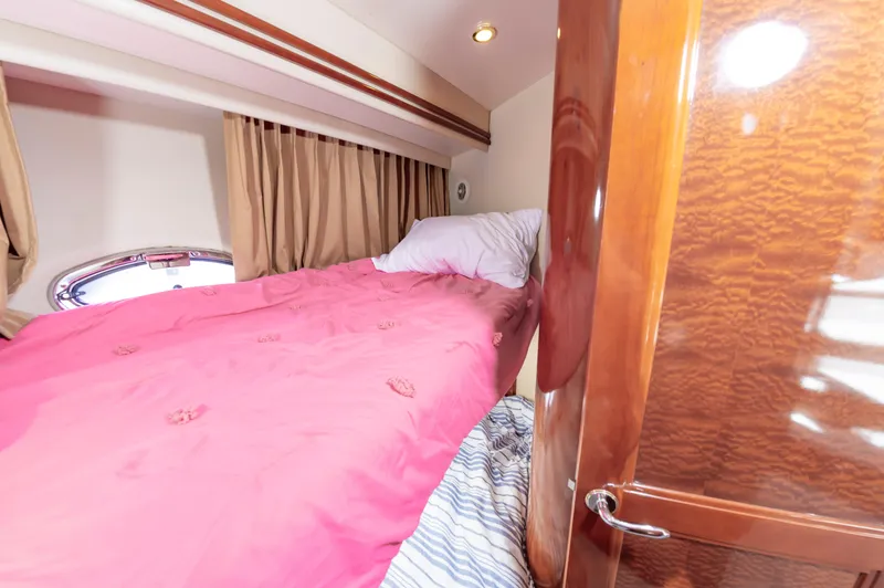 Slide: The Image of 2004 Carver 56 Voyager SE bedroom with pink bedding and wooden door - 32