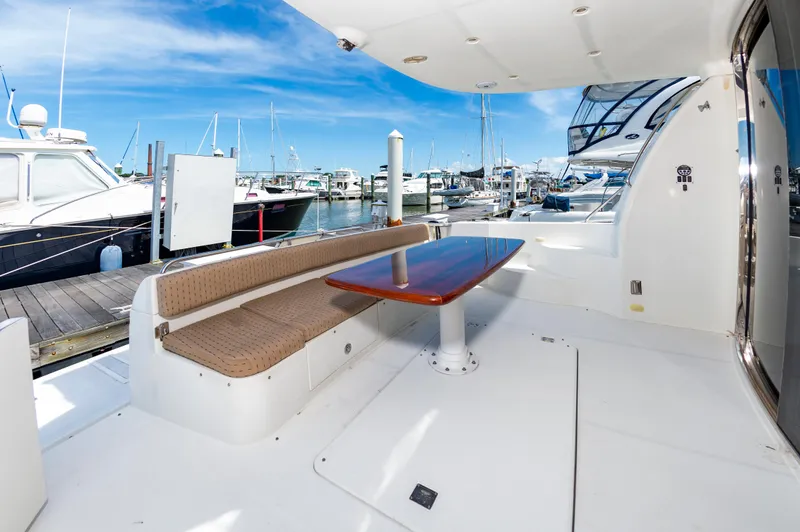 Slide: The Image of 2004 Carver 56 Voyager SE yacht with outdoor seating and table at marina. - 40
