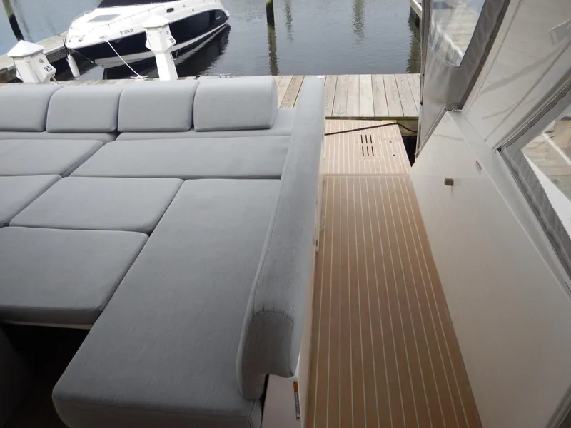 Slide: The Image of Sealine S450 2012 with gray sofa and wooden deck at the harbor. - 8