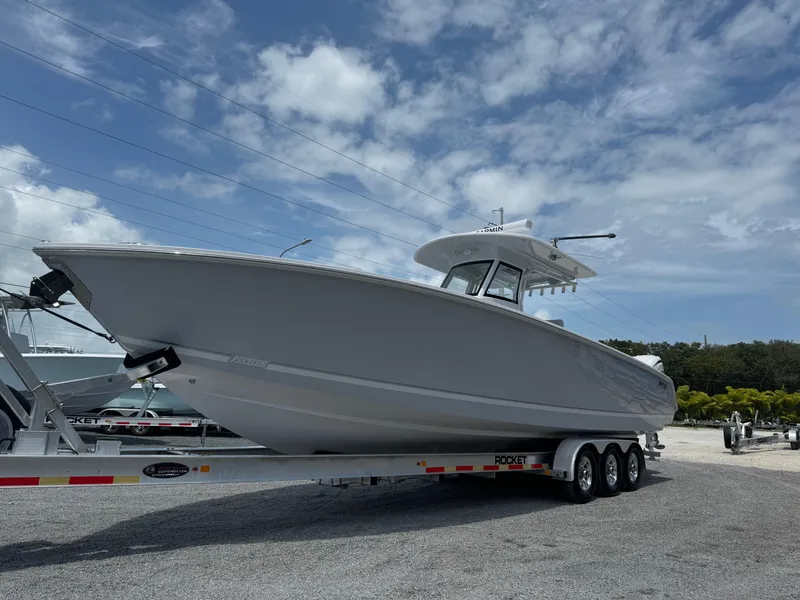 Slide: The Image of 2024 Jupiter 340LS boat on trailer under cloudy sky. - 0