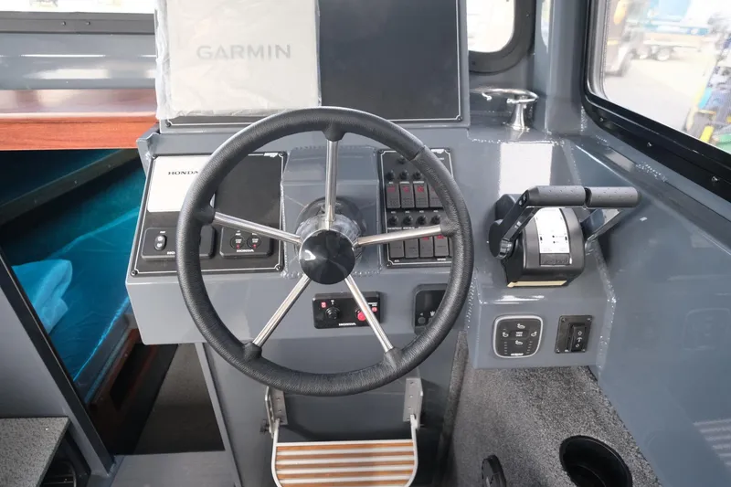 Slide: The Image of 2024 Hewescraft 250 Explorer boat cockpit with steering wheel and Garmin navigation system. - 14