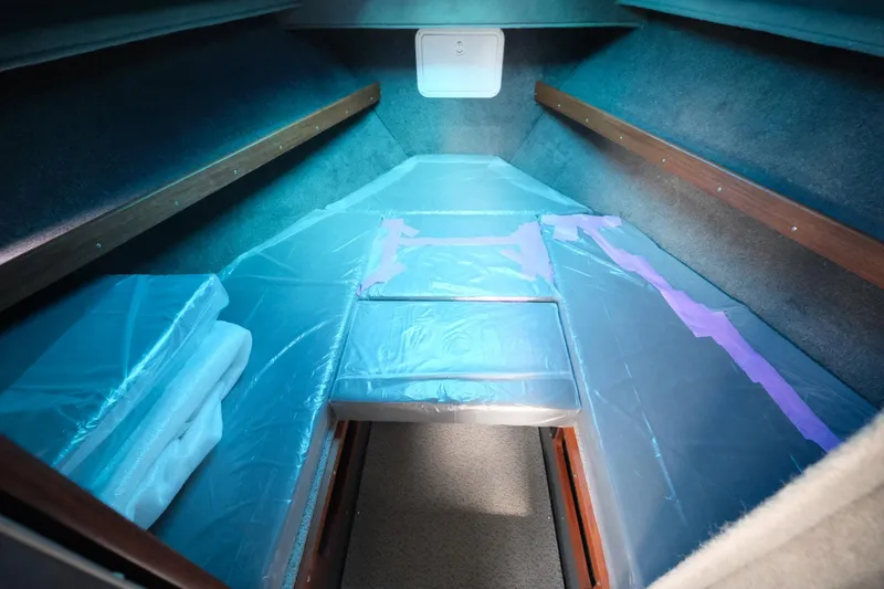 Slide: The Image of Interior cabin of 2024 Hewescraft 250 Explorer boat, featuring cushioned seating and storage. - 15