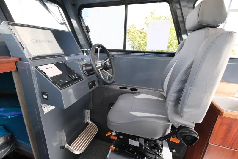 Slide: The Image of 2024 Hewescraft 250 Explorer interior with steering wheel and captain's chair. - 13