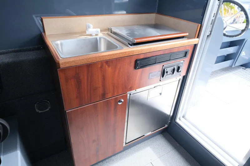 Slide: The Image of 2024 Hewescraft 250 Explorer interior kitchenette with sink and stove. - 18