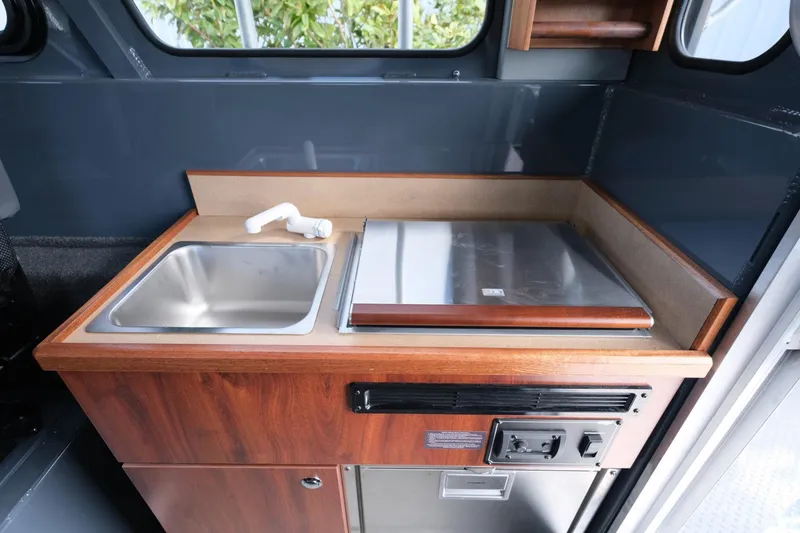Slide: The Image of 2024 Hewescraft 250 Explorer interior kitchen with sink and stove. - 19