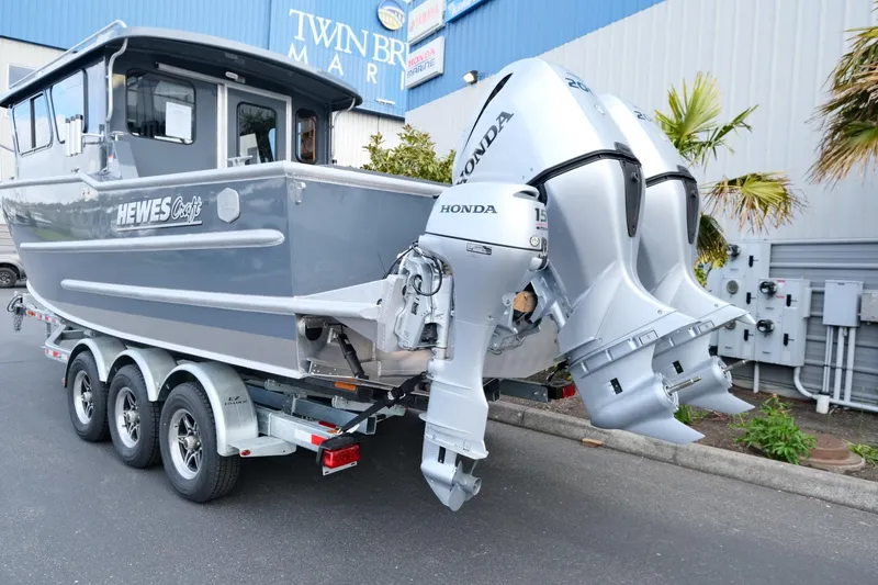 Slide: The Image of 2024 Hewescraft 250 Explorer boat with dual Honda outboard motors on a trailer. - 5