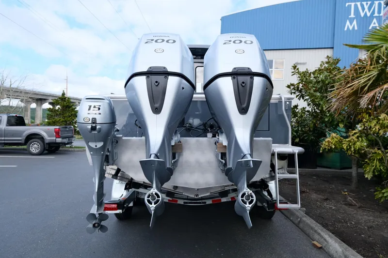 Slide: The Image of 2024 Hewescraft 250 Explorer with triple outboard motors in a parking lot. - 6