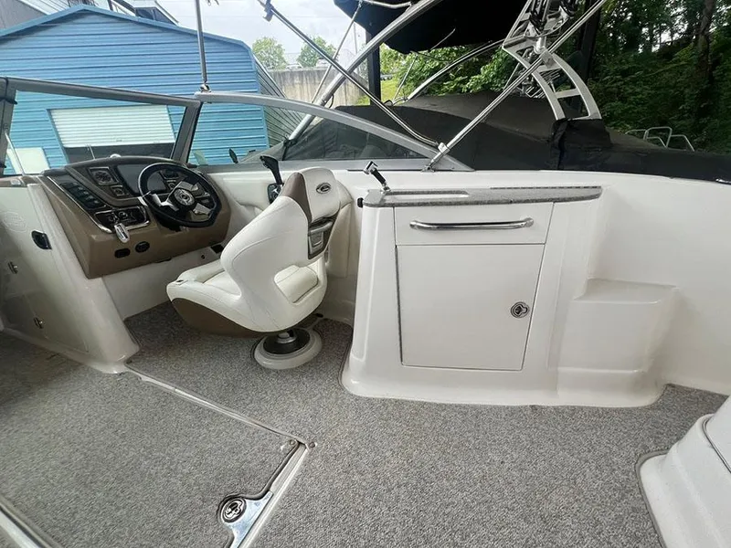 Slide: The Image of 2013 Chaparral 244 Sunesta boat interior with captain's chair and control panel. - 10