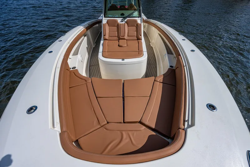 Slide: The Image of 2017 Scout 420 LXF boat with tan leather seating on the water. - 14