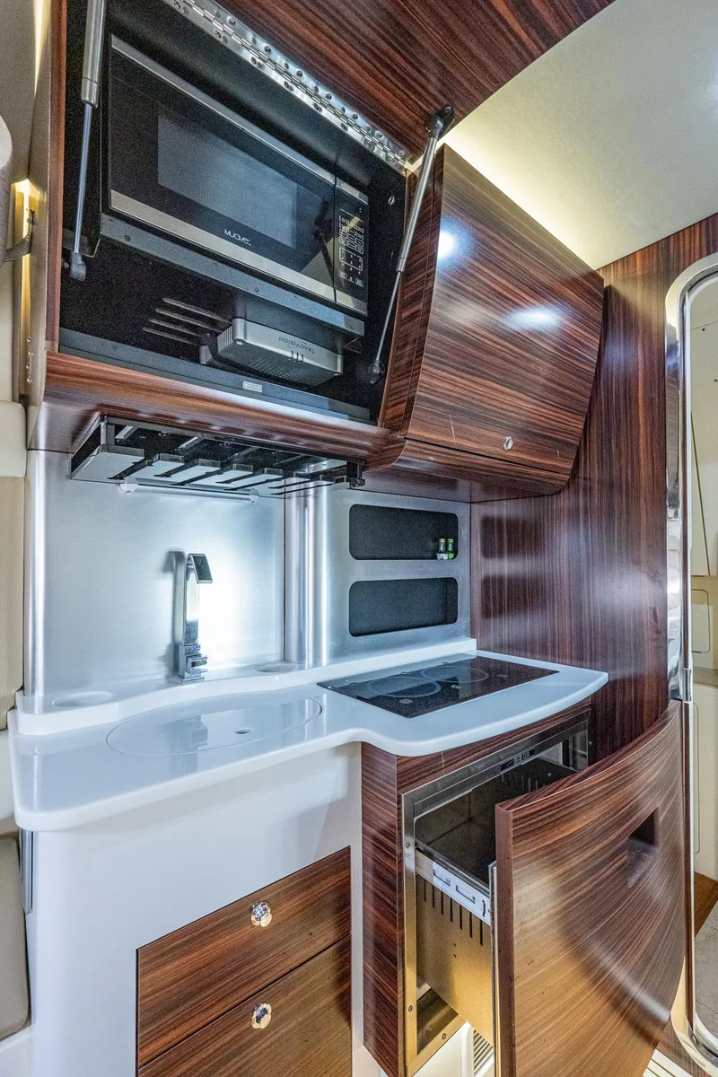 Slide: The Image of 2017 Scout 420 LXF yacht kitchen with modern appliances and wood finish. - 23
