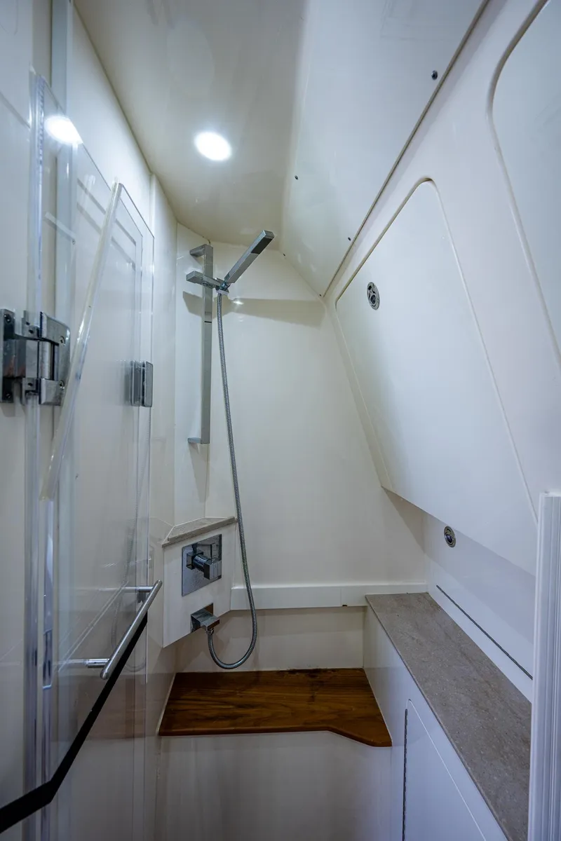 Slide: The Image of 2017 Scout 420 LXF boat interior shower with modern fixtures and wooden accents. - 27