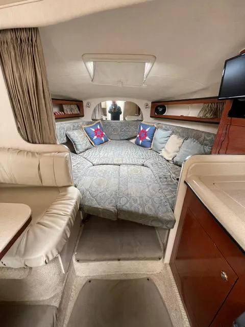 Slide: The Image of 2004 Sea Ray 280 Sundancer cabin interior with cozy seating and nautical decor. - 13