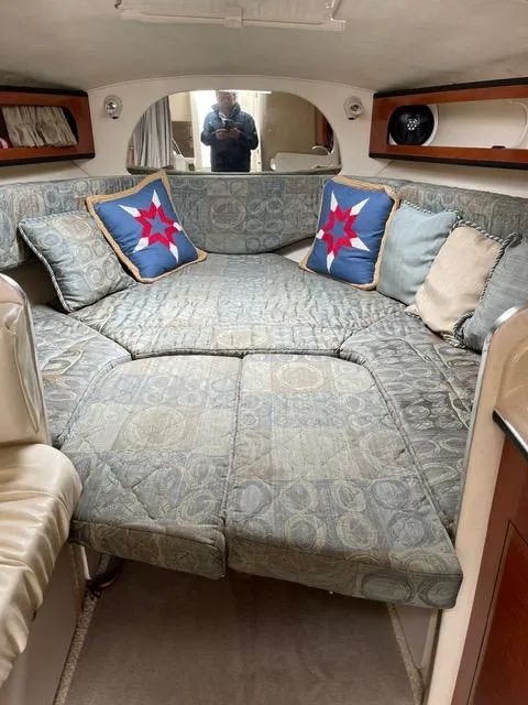 Slide: The Image of Interior cabin of a 2004 Sea Ray 280 Sundancer with cushioned seating and star-themed pillows. - 7