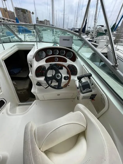 Slide: The Image of 2004 Sea Ray 280 Sundancer helm with steering wheel and control panel at marina. - 9