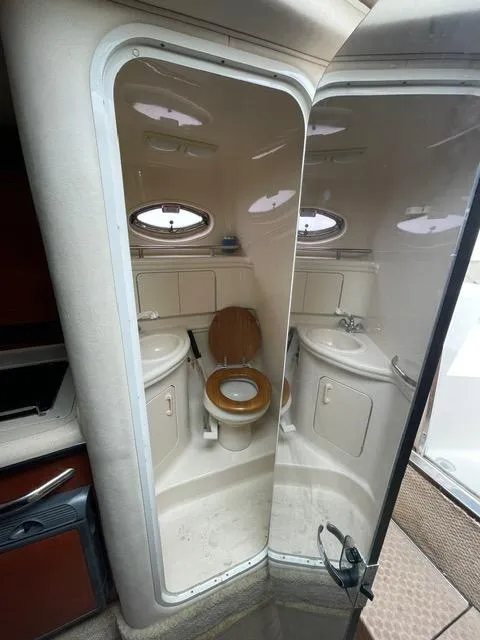 Slide: The Image of 2004 Sea Ray 280 Sundancer boat bathroom with toilet, sink, and mirror. - 8
