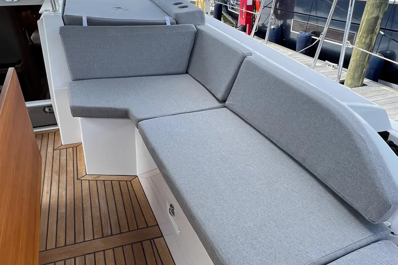 Slide: The Image of Beneteau Oceanis 46.1 2020 yacht with sleek gray seating and wooden deck. - 39