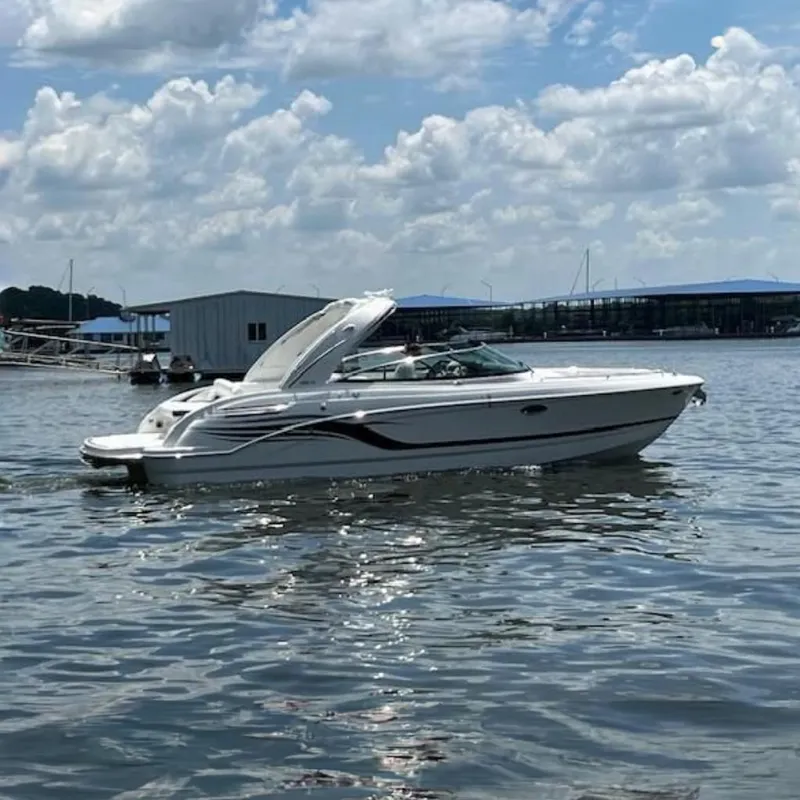 The Image of 2025 Formula 290 Bowrider boat cruising on a lake near a marina. - 0