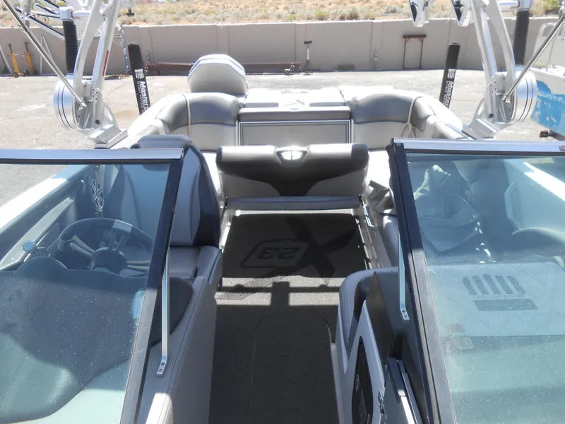 Slide: The Image of 2016 MasterCraft X23 boat interior with seating and glass windshields. - 11
