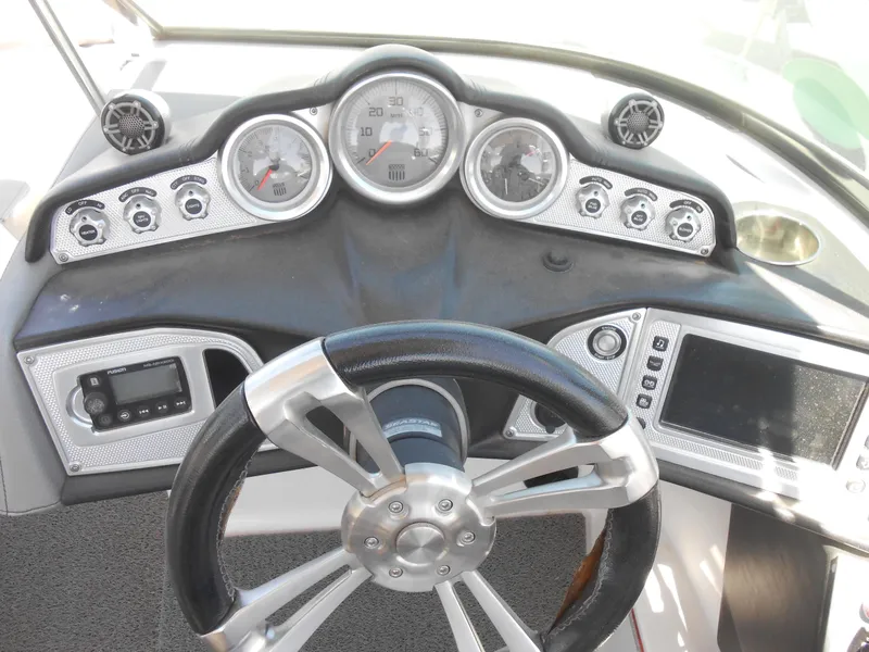 Slide: The Image of 2016 MasterCraft X23 boat dashboard with steering wheel, gauges, and control panel. - 8