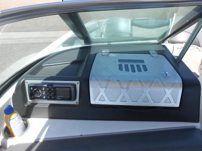 Slide: The Image of 2016 MasterCraft X23 boat dashboard with stereo system and storage compartment. - 9