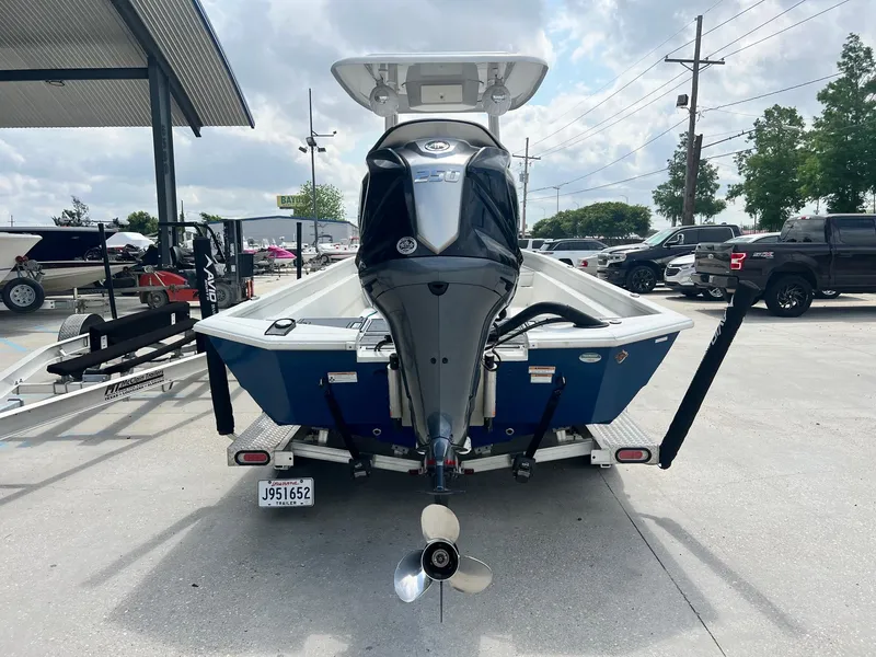 Slide: The Image of Avid 23 Mag 2022 boat on trailer, rear view with motor, parked outdoors. - 8