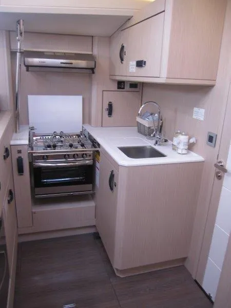 Slide: The Image of Modern kitchen in 2024 Jeanneau 60 yacht with stove, sink, and cabinetry. - 16
