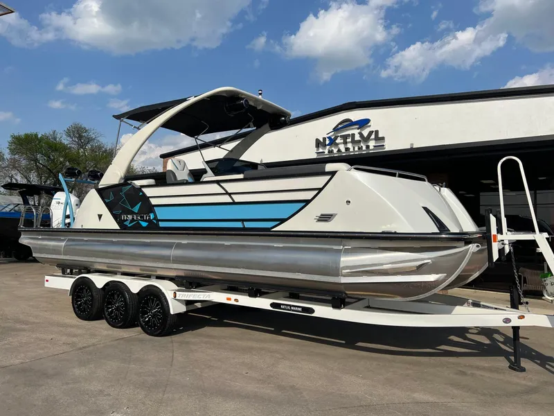 Slide: The Image of 2024 Trifecta 25 SPORT RL9 DC 3PLUS ARCH pontoon boat on trailer at dealership. - 1