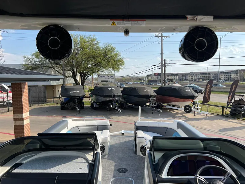 Slide: The Image of 2024 Trifecta 25 SPORT RL9 DC 3PLUS ARCH boat interior with covered boats in the background. - 18