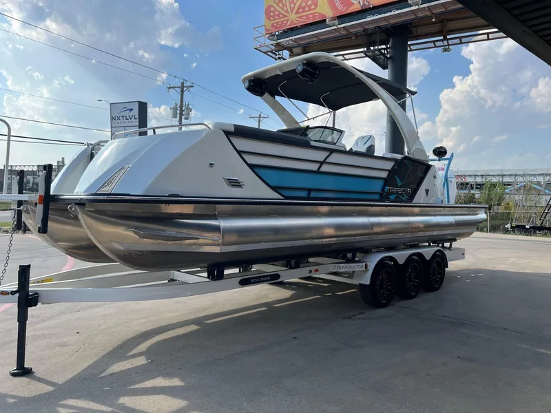 Slide: The Image of 2024 Trifecta 25 SPORT RL9 DC 3PLUS ARCH pontoon boat on trailer, outdoor display. - 7