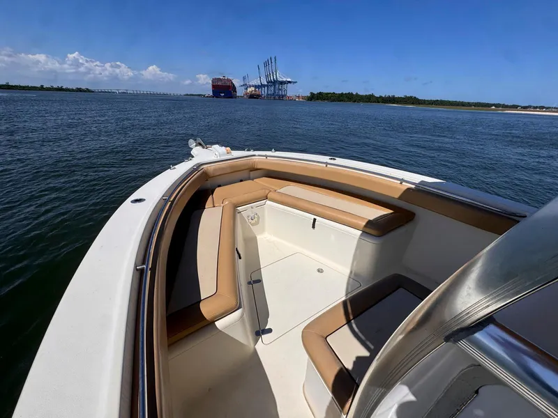 Slide: The Image of 2002 Scout 280 Sportfish boat on open water with port in background. - 13