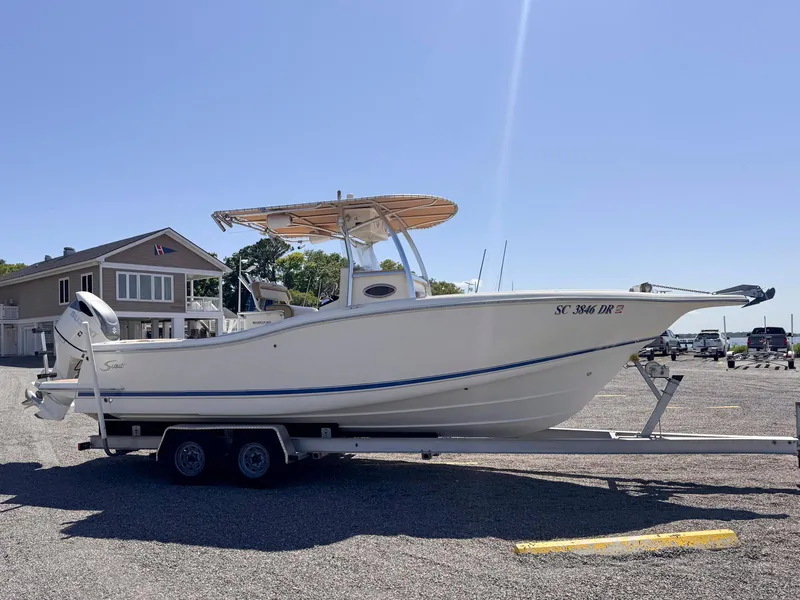 Slide: The Image of 2002 Scout 280 Sportfish boat on a trailer in a parking lot. - 7