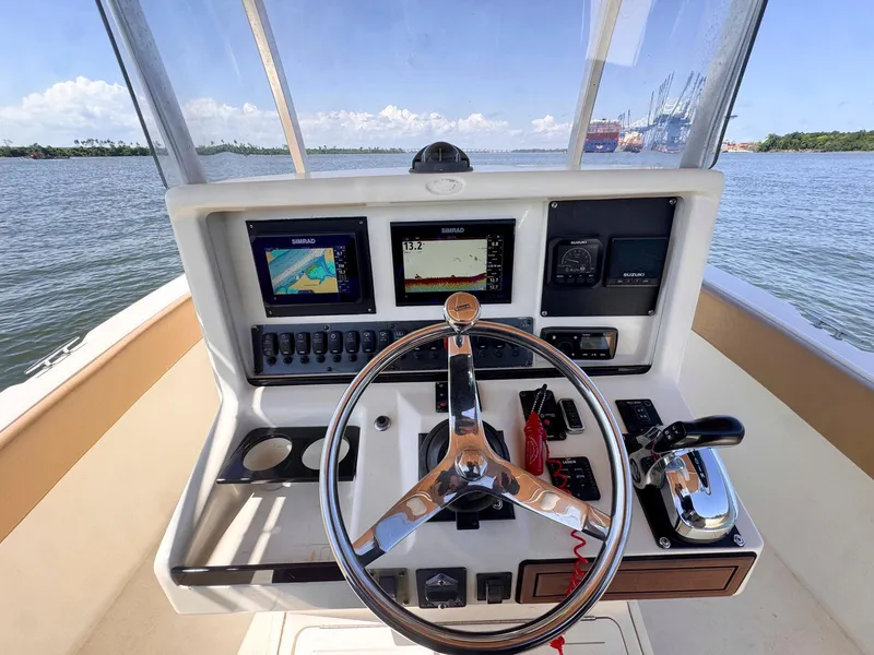 Slide: The Image of 2002 Scout 280 Sportfish helm with navigation screens and steering wheel. - 9