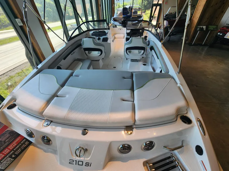 Slide: The Image of 2024 Tahoe 210 Si boat interior with sleek seating and modern design in showroom. - 2