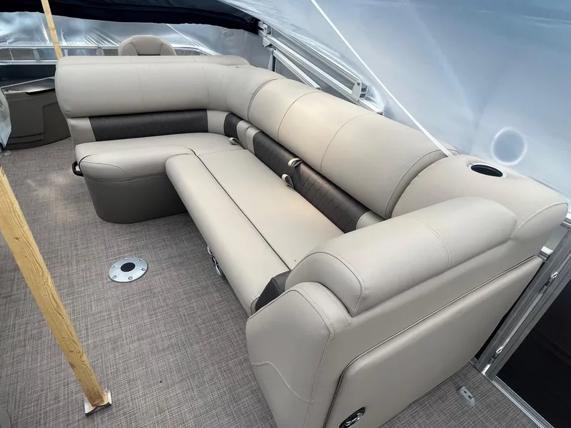 Slide: The Image of 2024 Sun Tracker Fishin' Barge 20 DLX interior with beige seating and carpeted floor. - 2