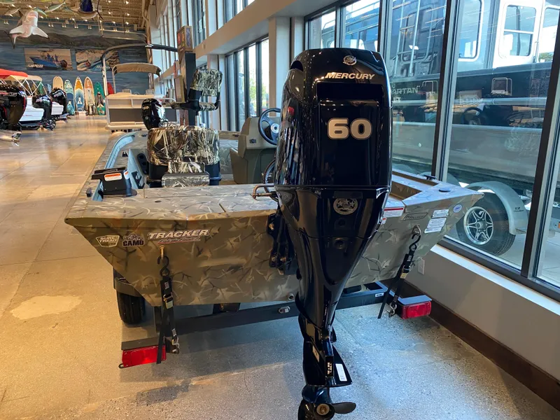 Slide: The Image of 2024 Tracker Grizzly 1754 SC boat with Mercury 60 engine displayed indoors. - 35
