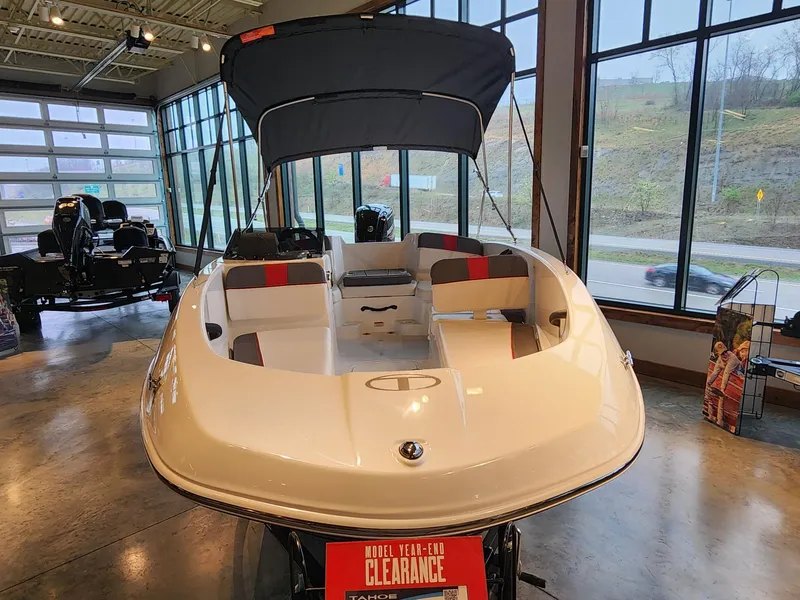 Slide: The Image of 2024 Tahoe T16 boat on display in showroom, featuring sleek design and clearance sale sign. - 2