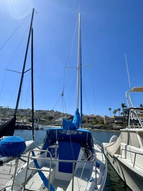 Slide: The Image of 1973 Ericson 27 sailboat docked at a marina on a sunny day. - 15