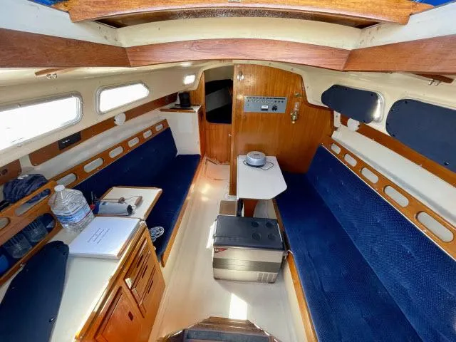 Slide: The Image of Interior of a 1973 Ericson 27 sailboat with blue seating and wooden accents. - 2