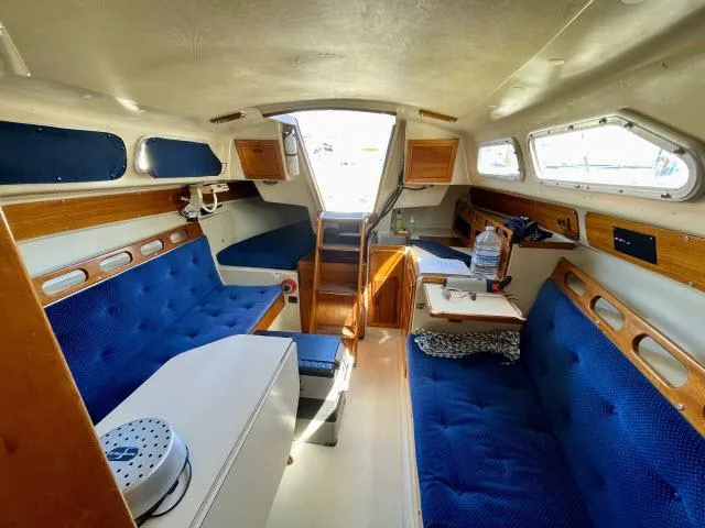 Slide: The Image of Interior of a 1973 Ericson 27 sailboat with blue cushioned seating. - 3