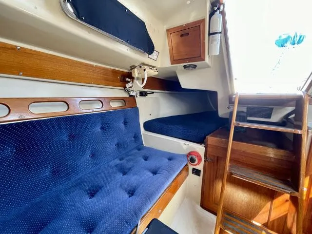 Slide: The Image of Interior of a 1973 Ericson 27 sailboat with blue cushioned seating. - 6