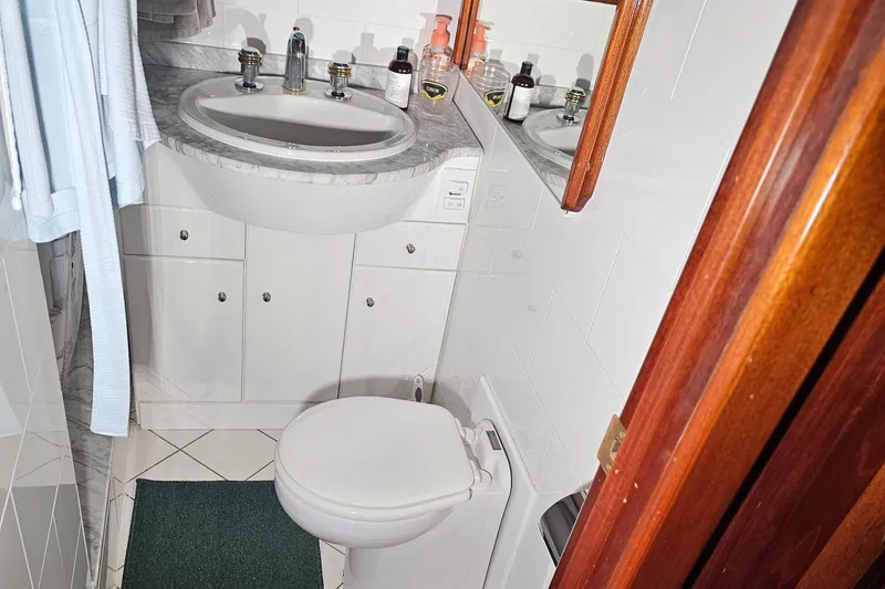 Slide: The Image of Interior hallway of a 1999 Florida Bay Coaster 42 with polished wooden flooring. - 46