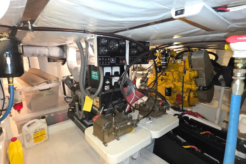 Slide: The Image of Engine room of 1999 Florida Bay Coaster 42 with mechanical components and control panel. - 66