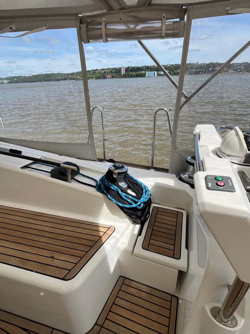 Slide: The Image of 2012 Beneteau Oceanis 58 yacht deck with wooden seating and water view. - 20