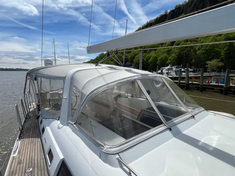 Slide: The Image of Beneteau Oceanis 58 sailboat, 2012 model, docked by a scenic shoreline. - 23