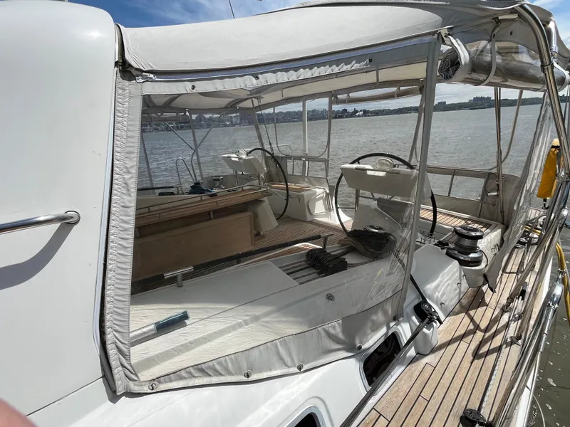 Slide: The Image of 2012 Beneteau Oceanis 58 yacht cockpit with clear enclosure, docked on a sunny day. - 40