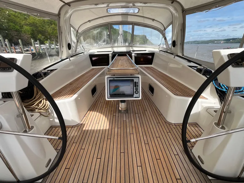 Slide: The Image of 2012 Beneteau Oceanis 58 yacht cockpit with dual steering wheels and teak flooring. - 44