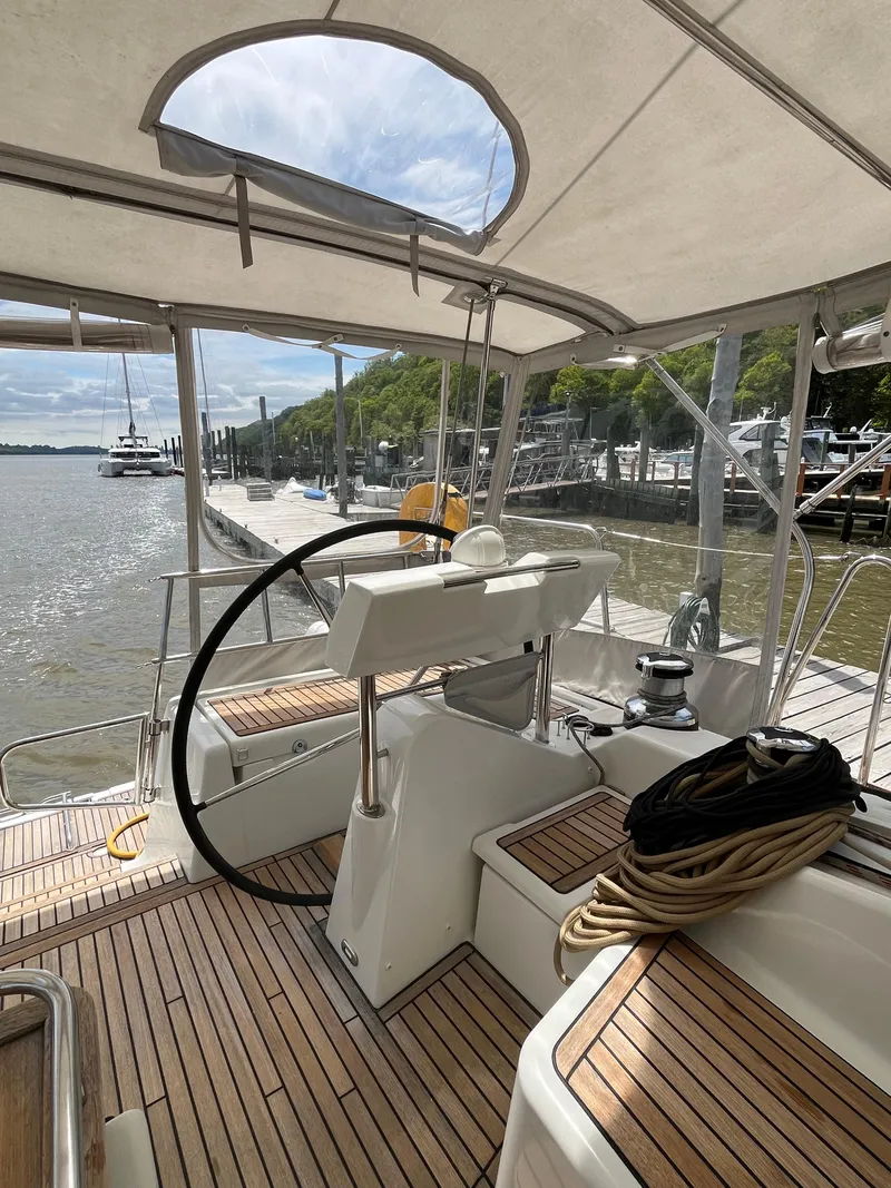 Slide: The Image of Beneteau Oceanis 58 sailboat cockpit, 2012 model, docked with scenic waterfront view. - 8