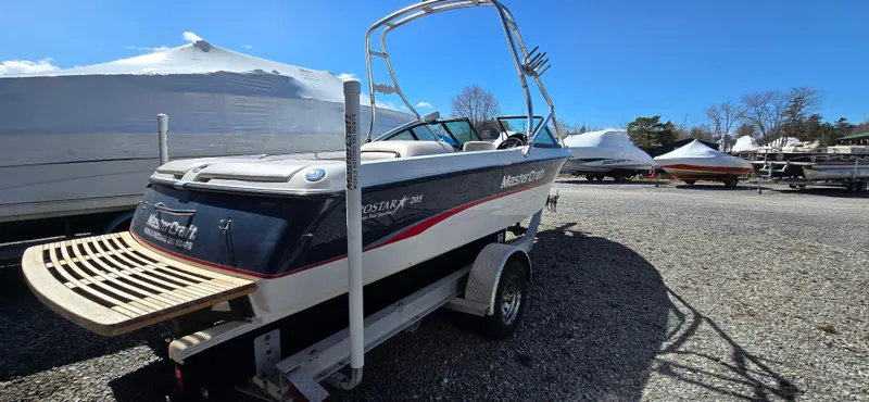 Slide: The Image of 1996 MasterCraft Prostar 205 boat on trailer in outdoor storage area. - 3